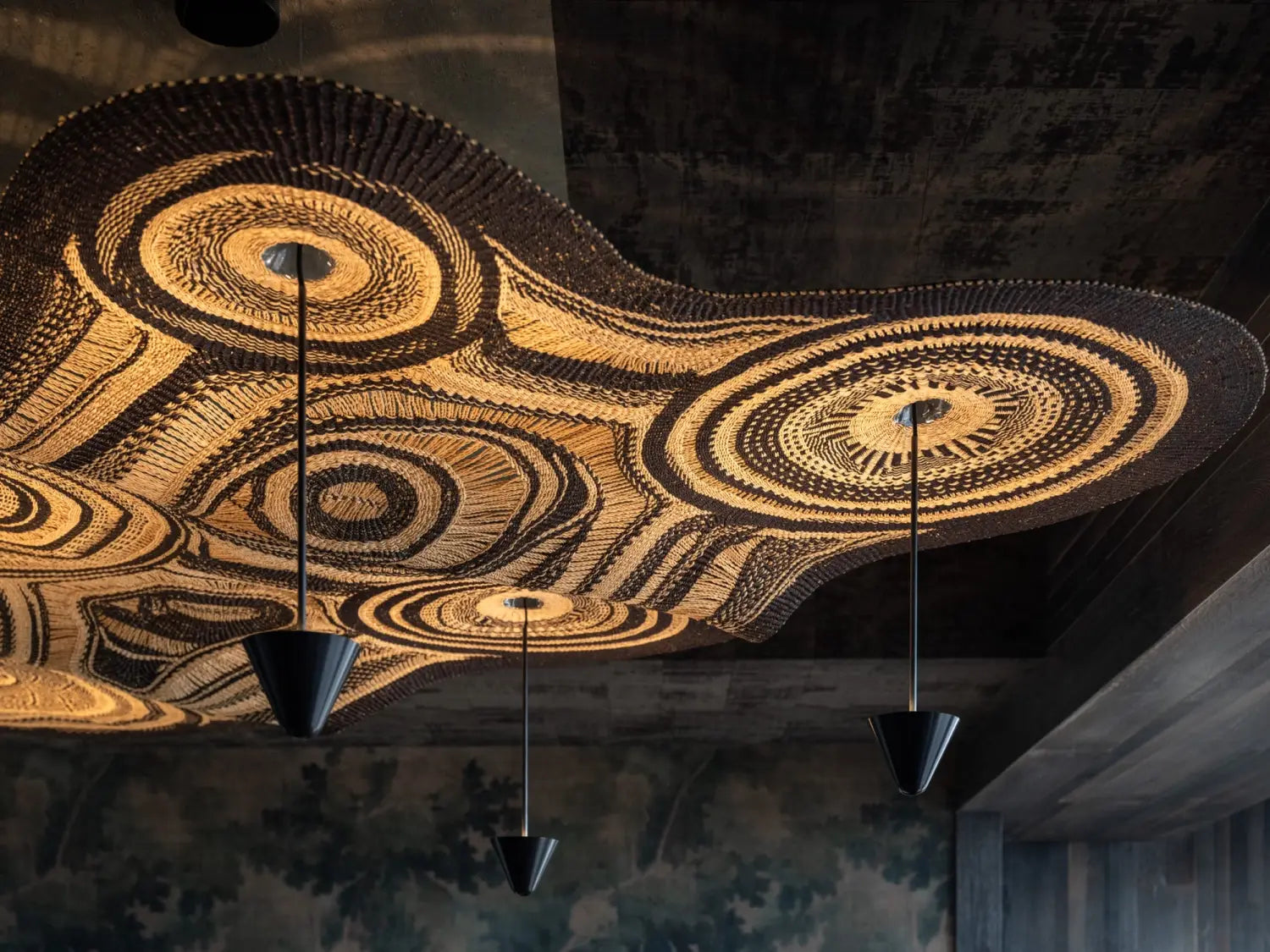 A detail of a sprawling light fixture produced by Ghanaian artisans in collaboration with PET Lamp with swirling, woven designs
